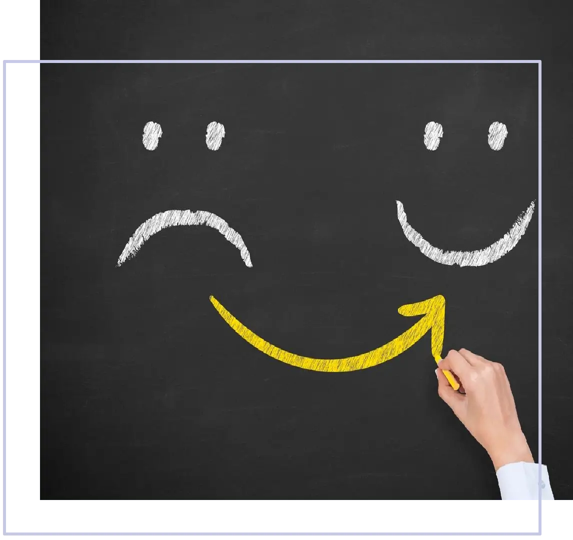 A person drawing two smiley faces on the wall.